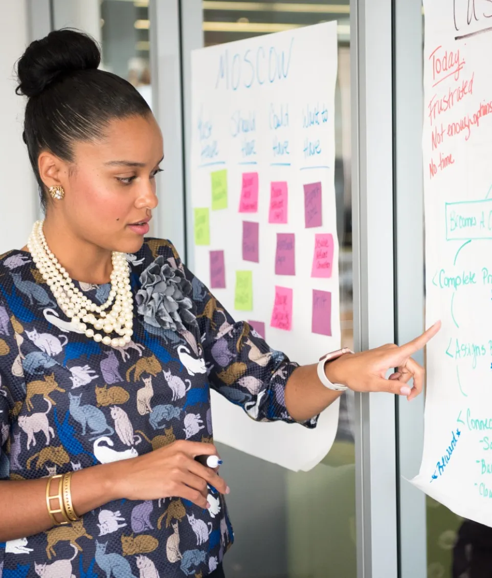 Woman from a digital agency pointing at colorful stickers on a board for about us page